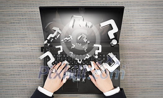 Top view of businesswoman using laptop and question marks Top view of businesswoman using laptop and question marks