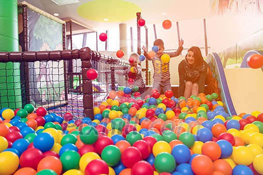 happy family enjoying free time young mom playing with kids in pool with colorful balls at childrens playroom happy family enjoying free time young mom playing with kids in pool with colorful balls at childrens playroom