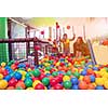 happy family enjoying free time young mom playing with kids in pool with colorful balls at childrens playroom