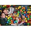 happy family enjoying free time young parents and kids playing in the pool with colorful balls at childrens playroom