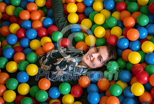happy family enjoying free time young mom playing with kids in pool with colorful balls at childrens playroom happy family enjoying free time young mom playing with kids in pool with colorful balls at childrens playroom
