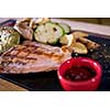 Juicy grilled steak with vegetables on a wooden board