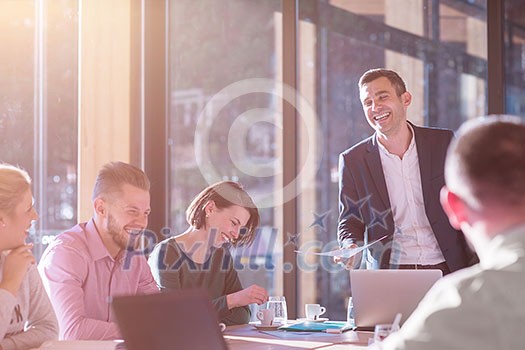 Group of a young business people brainstorming and discussing business plan on meeting at sunny bright office interior Group of a young business people brainstorming and discussing business plan on meeting at sunny bright office interior
