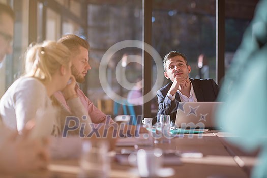 Group of a young business people brainstorming and discussing business plan on meeting at sunny bright office interior Group of a young business people brainstorming and discussing business plan on meeting at sunny bright office interior
