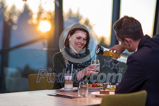 young happy loving couple enjoying romantic dinner while celebrating Valentines day near the window at luxury restaurant young happy loving couple enjoying romantic dinner while celebrating Valentines day near the window at luxury restaurant
