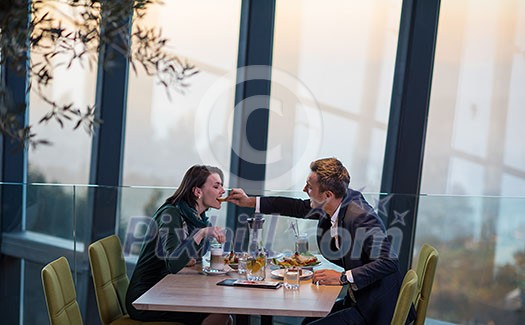 young happy loving couple enjoying romantic dinner while celebrating Valentines day near the window at luxury restaurant young happy loving couple enjoying romantic dinner while celebrating Valentines day near the window at luxury restaurant