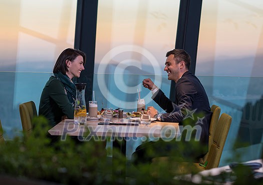 young happy loving couple enjoying romantic dinner while celebrating Valentines day near the window at luxury restaurant young happy loving couple enjoying romantic dinner while celebrating Valentines day near the window at luxury restaurant