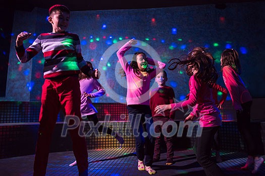 A group of joyful children happily spending time at Kids neon disco party A group of joyful children happily spending time at Kids neon disco party