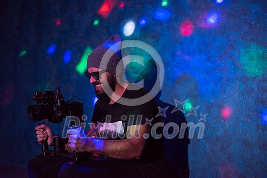 young videographer with gimball video slr working in kids neon disco party young videographer with gimball video slr working in kids neon disco party