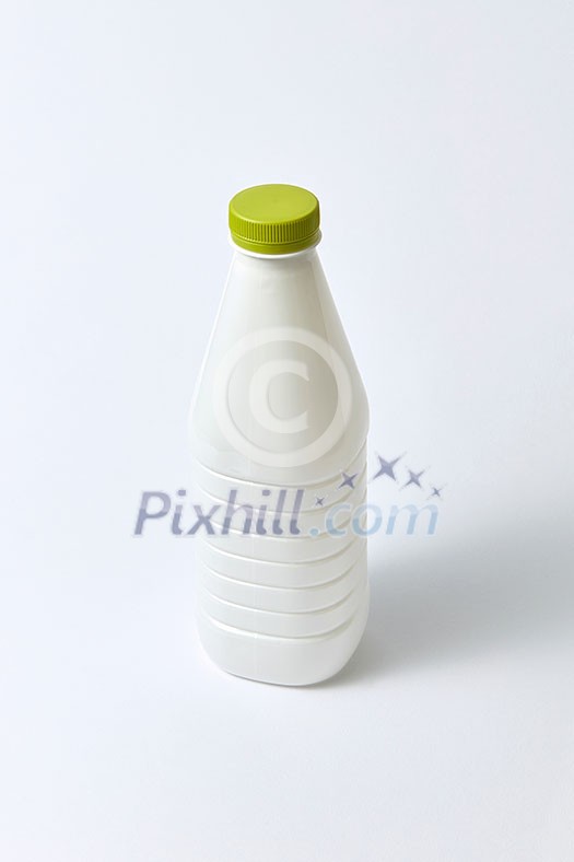 Plastic blank white bottle for milk and other liquid with green cap on a light gray background, copy space. Plastic blank white bottle for milk and other liquid with green cap on a light gray background, copy space.