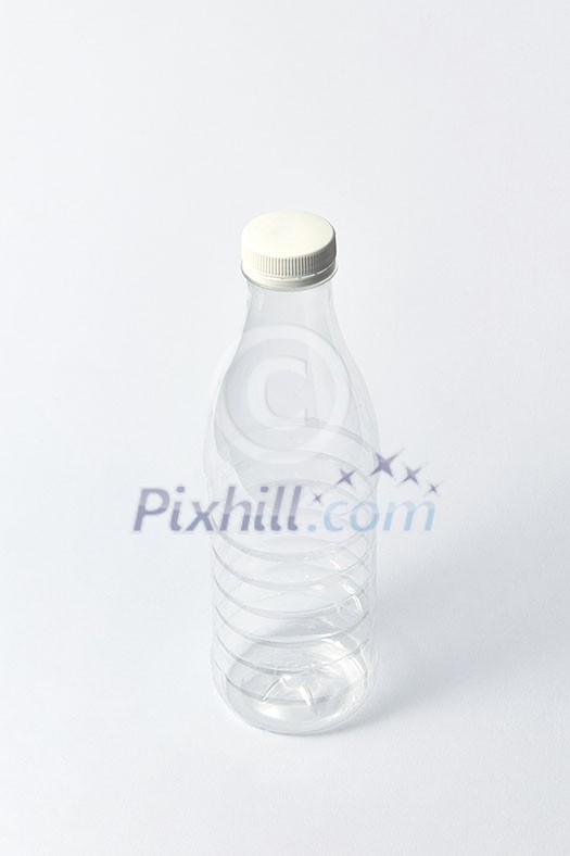 Plastic transparent empty bottle for dairy products, water and other liquid with white cup on a light gray background, mock up. Copy space. Plastic transparent empty bottle for dairy products, water and other liquid with white cup on a light gray background, mock up. Copy space.