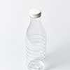 Plastic transparent empty bottle for dairy products, water and other liquid with white cup on a light gray background, mock up. Copy space.