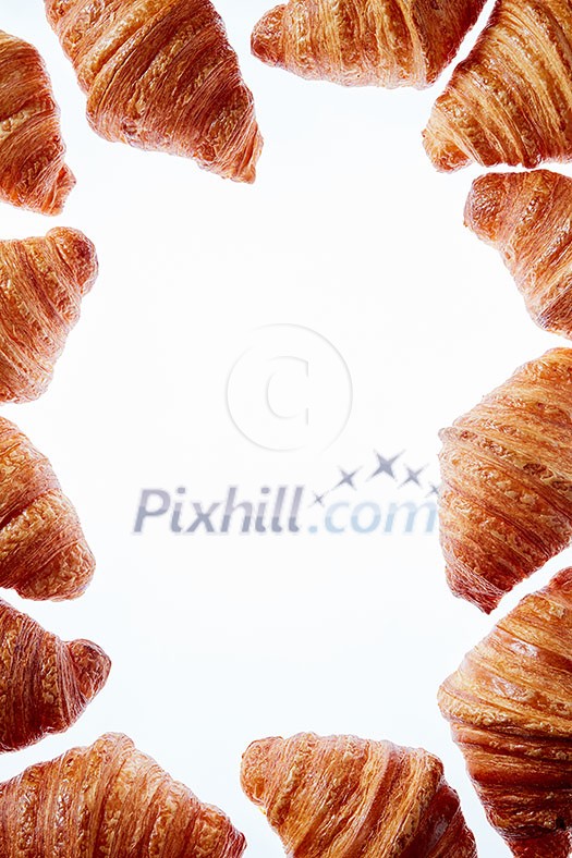 Homemade freshly baked pastry in the form of frame with french croissants on a white background, copy space. Homemade freshly baked pastry in the form of frame with french croissants on a white background, copy space.