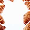 Homemade freshly baked pastry in the form of frame with french croissants on a white background, copy space.