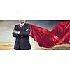 Aged businessman in red cape with arms crossed on chest. Mixed media