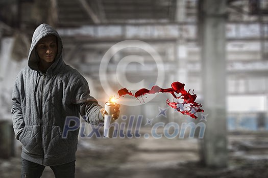 Man hiding face with hoodie and spraying paint with balloon. Mixed media Man hiding face with hoodie and spraying paint with balloon. Mixed media