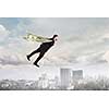 Businessman with dollar banknotes as wings flying in sky. Mixed media