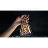 Close up image of human hand holding test tube with money symbol