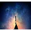 Silhouette of exclamation mark on rock peak against starry sky. Mixed media