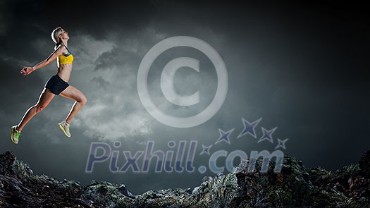 Slim attractive sportswoman running up the hill. Mixed media Slim attractive sportswoman running up the hill. Mixed media