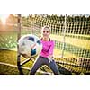 Teen female goalie catching a shot during a soccer game