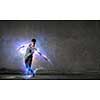 Breakdancer in jump in empty concrete room. Mixed media