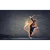 Breakdancer in jump in empty concrete room. Mixed media