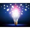 Glowing bright light bulb on dark background