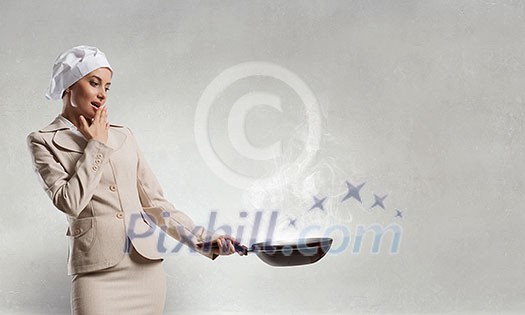 Young elegant businesswoman in suit and cook hat with pan in hands. Mixed media Young elegant businesswoman in suit and cook hat with pan in hands. Mixed media
