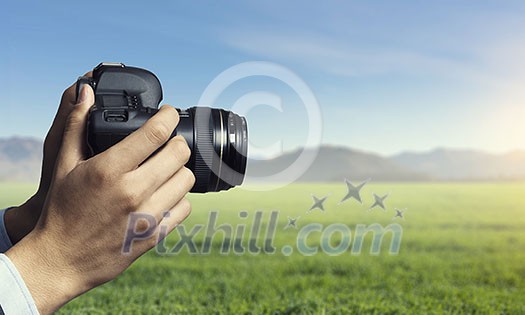 Close of professional photographer holding photo camera