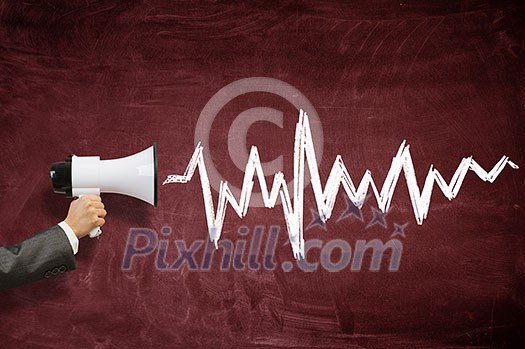 Hand of person holding megaphone against chalkboard background Hand of person holding megaphone against chalkboard background