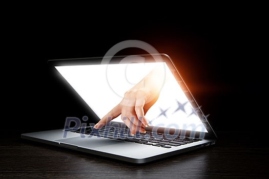 Hand coming out of laptop monitor. Mixed media Hand coming out of laptop monitor. Mixed media
