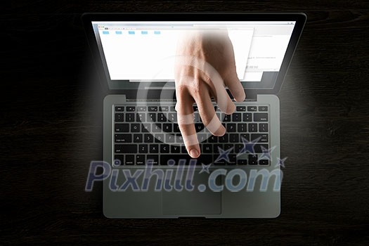 Hand coming out of laptop monitor. Mixed media Hand coming out of laptop monitor. Mixed media