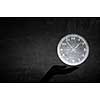 Close up of businessman hand holding clock icon in palm