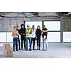 young multiethnic team of business people in group, architect and engineer on construction site checking documents and business workflow using laptop and tablet computer in new startup office