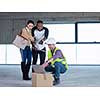 young multiethnic team of business people in group, architect and engineer on construction site checking documents and business workflow using laptop and tablet computer in new startup office