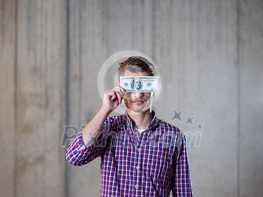 business, people and finances concept happy young business man holding american dollars banknote over the eyes in new startup office business, people and finances concept happy young business man holding american dollars banknote over the eyes in new startup office