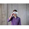business, people and finances concept  happy young business man holding american dollars banknote over the eyes  in new startup office