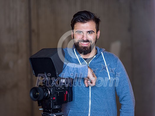 portrait of young videographer with a professional camera at work portrait of young videographer with a professional camera at work