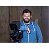 portrait of young videographer with a professional camera at work