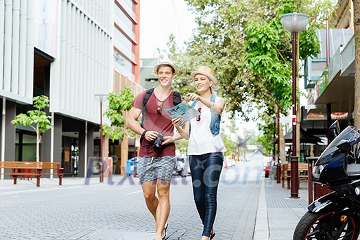Happy young couple as tourists with a map Happy young couple as tourists with a map