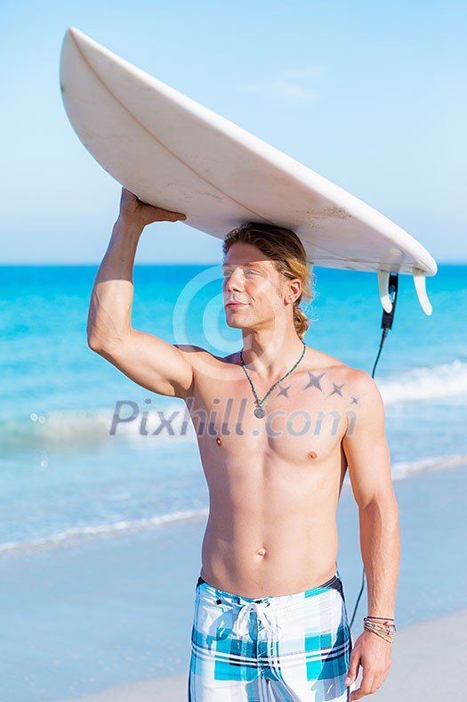 A young surfer with his board on the beach A young surfer with his board on the beach
