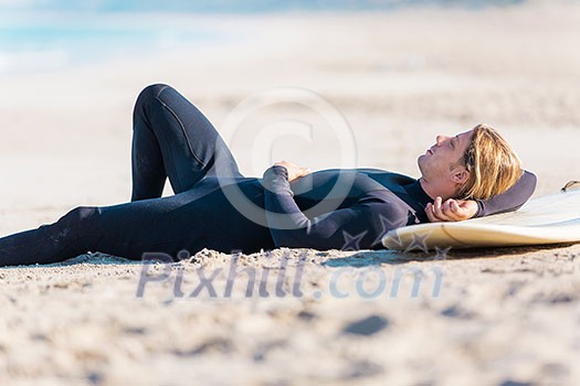 A young surfer with his board on the beach A young surfer with his board on the beach