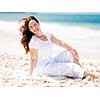 Woman in white clothes on the beach on sunny day
