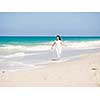 Woman in white clothes on the beach on sunny day