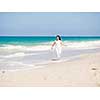 Woman in white clothes on the beach on sunny day