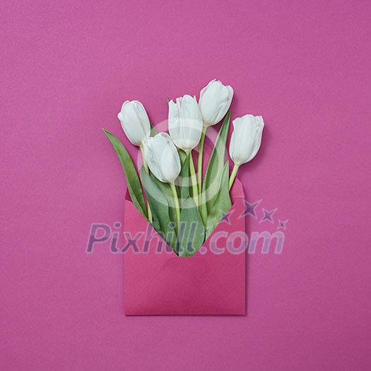 Congratulation post card of handcraft envelope of white tulips on a purple background with place for text. Flat lay. Congratulation post card of handcraft envelope of white tulips on a purple background with place for text. Flat lay.