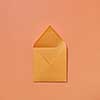 Mock up handmade open envelope for love letter on a light peach color background with copy space. Top view.