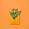 Spring fresh flowers tulips in craft envelope on a yellow background with copy space. Love letter for congratulation. Flat lay