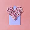 Congratulation card with flowers heart and handcraft envelope on a pastel background. Top view.